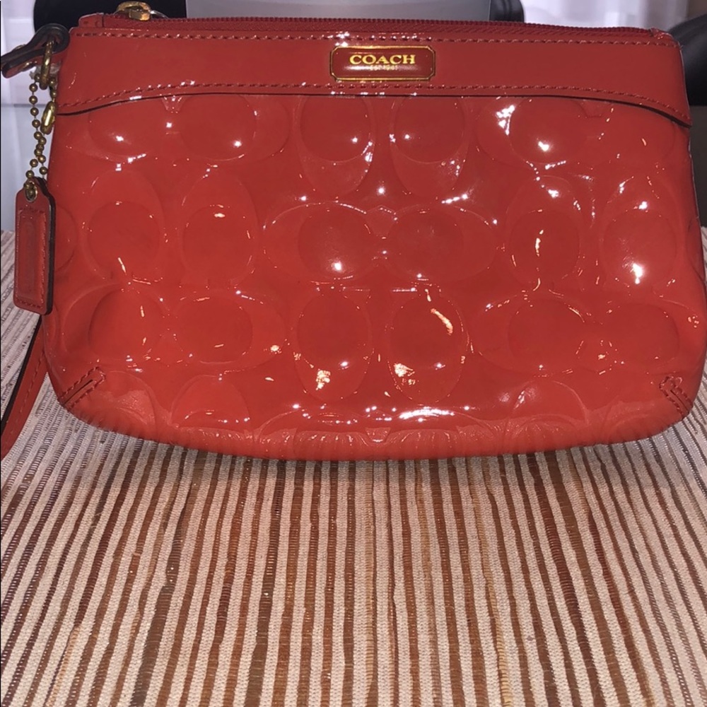 Coral, patent leather genuine Coach wristlet.